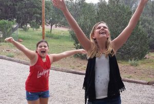 Two girls are playing with a ball in the park.