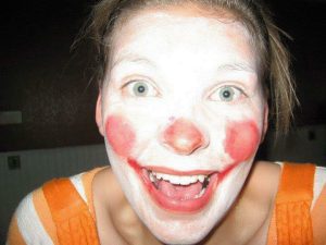 A woman with clown makeup on her face.