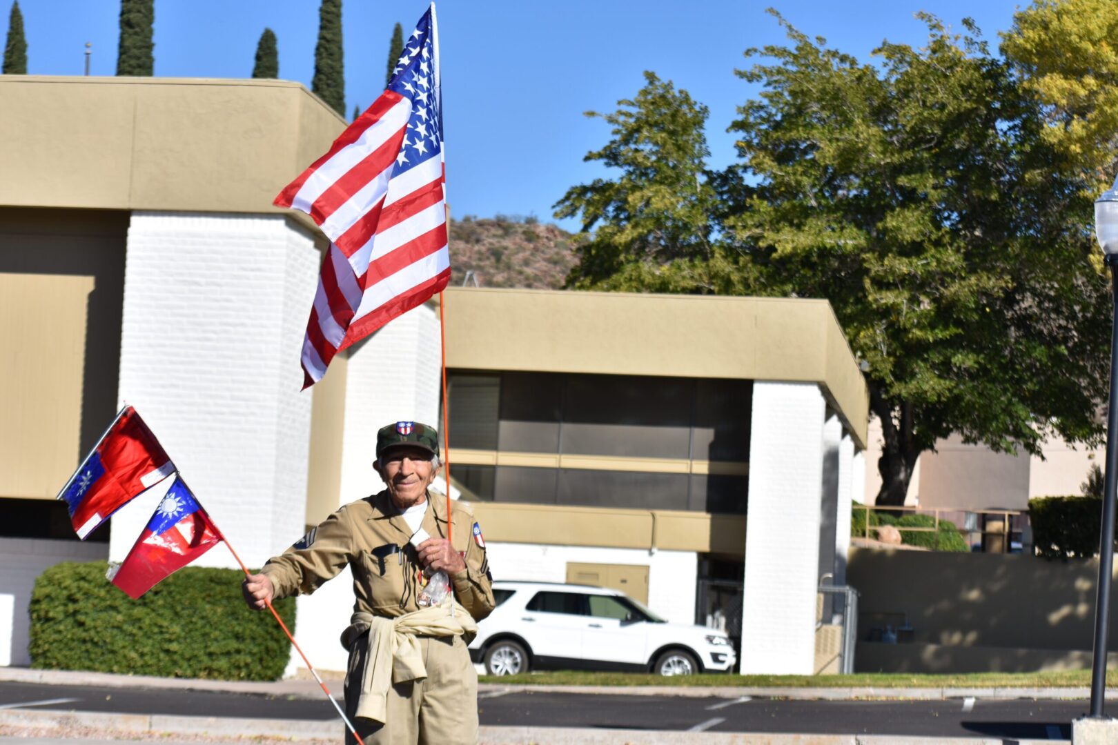 A man in uniform holding an american flag.