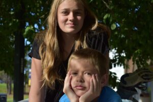 A young girl and boy posing for the camera.