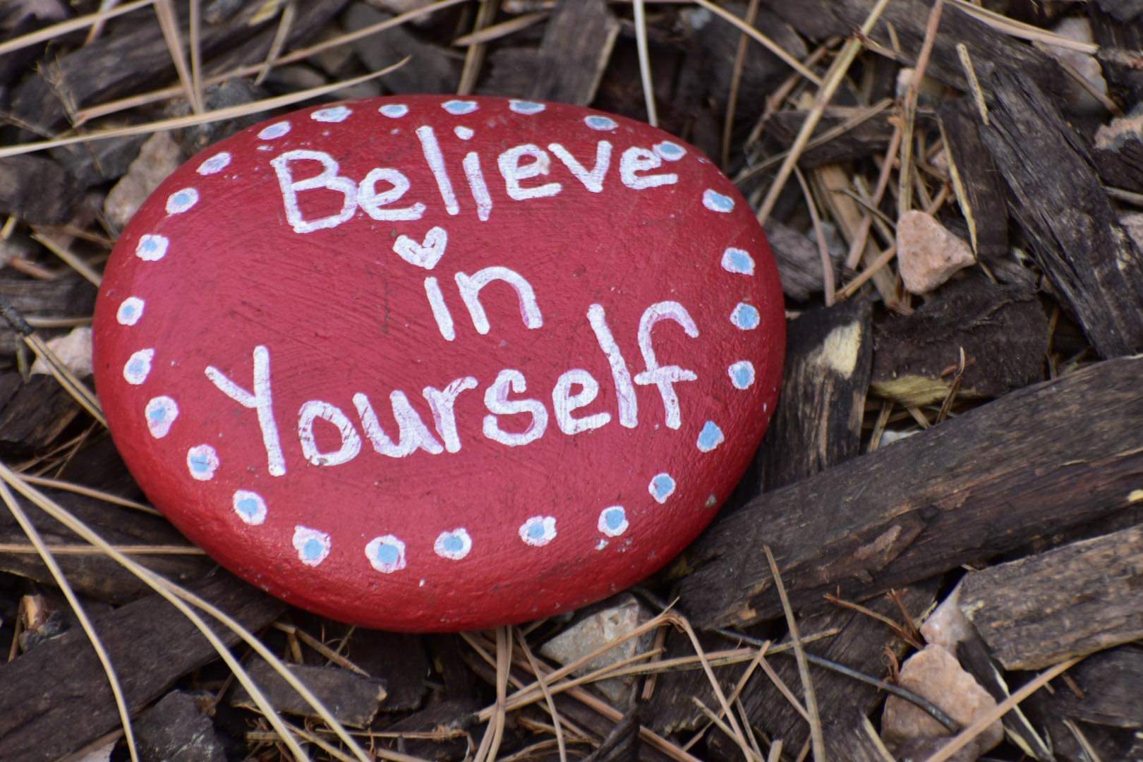 A red rock with the words " believe in yourself ".