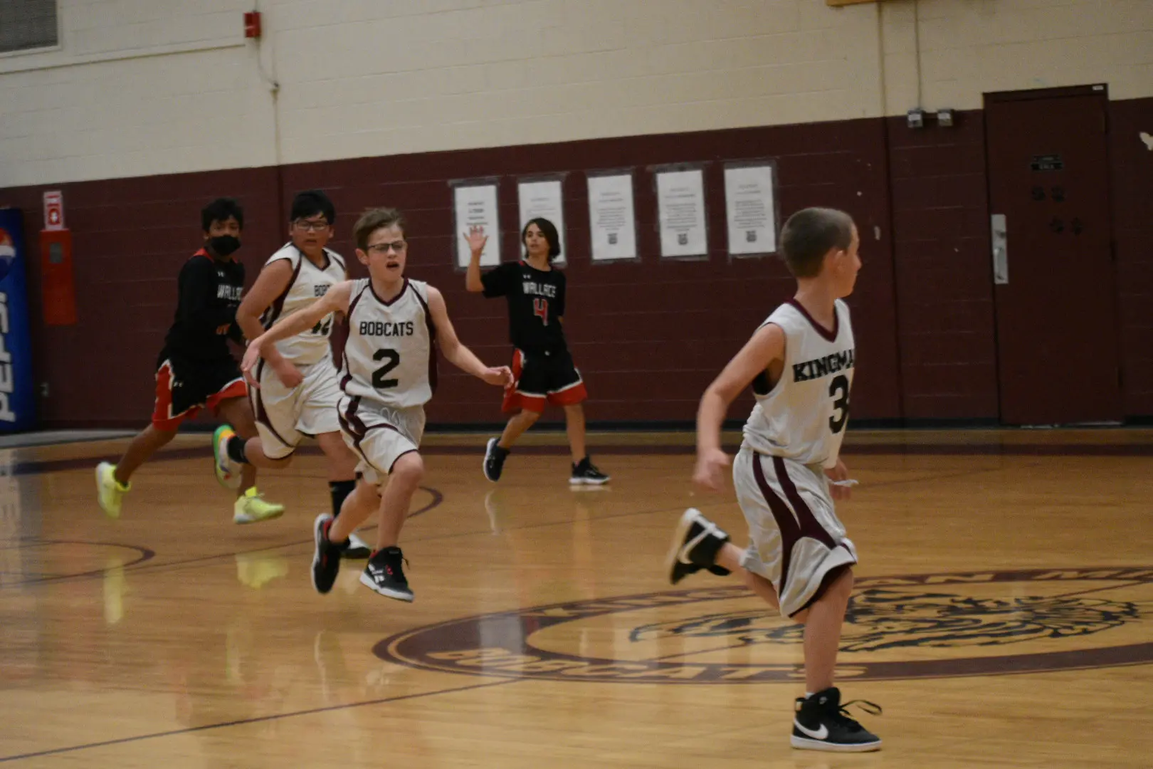 A group of young boys playing basketball on the court.