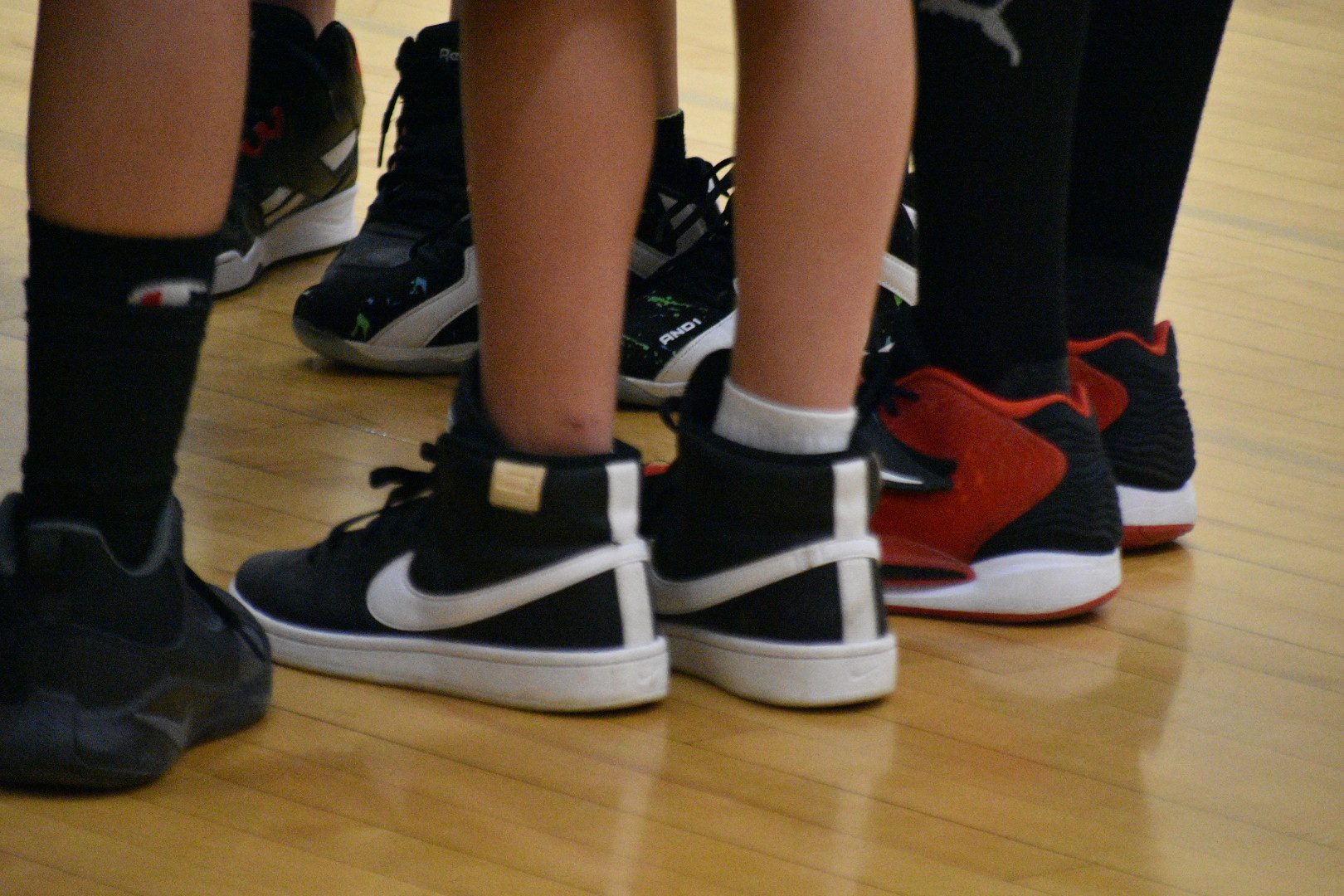 A group of people standing on the floor with their feet up.