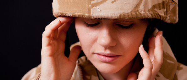 A woman in uniform is holding her head.