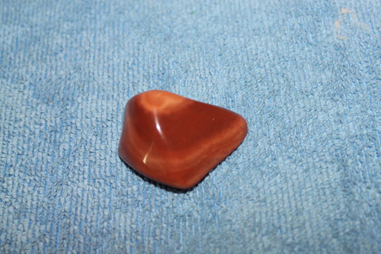 A red stone sitting on top of a blue carpet.