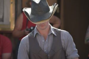 A man wearing a cowboy hat and vest.