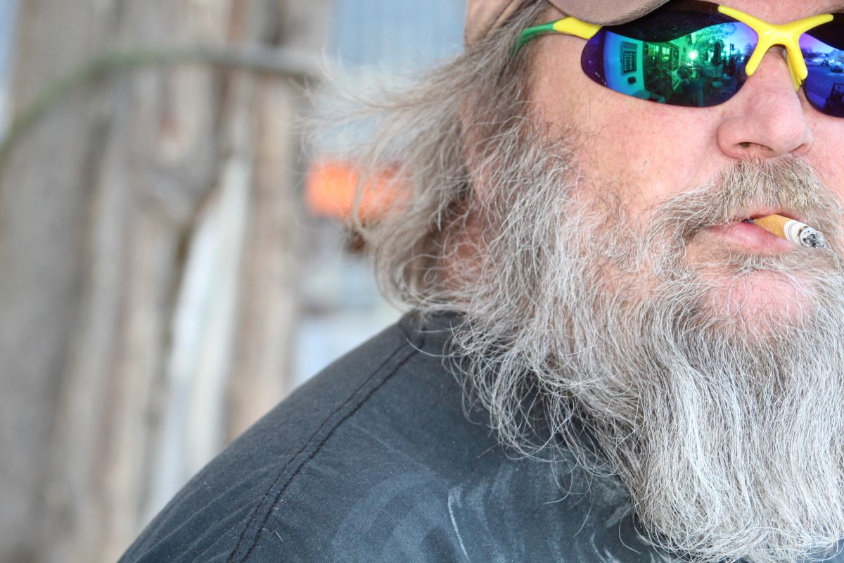 A man with long grey hair and sunglasses.