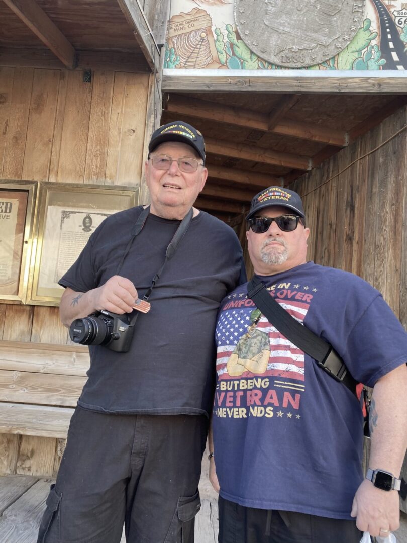 Two men standing next to each other holding cameras.