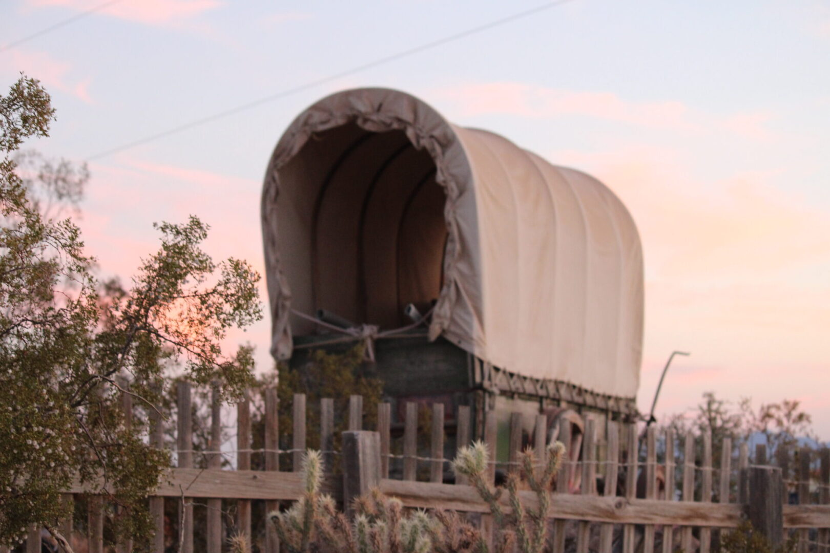 A covered wagon sitting on top of a wooden fence.