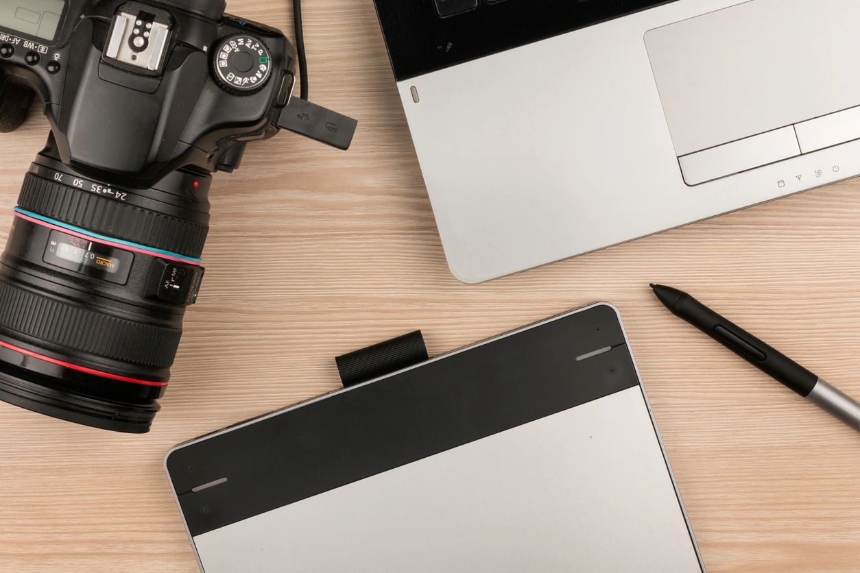 A camera and laptop on top of a table.