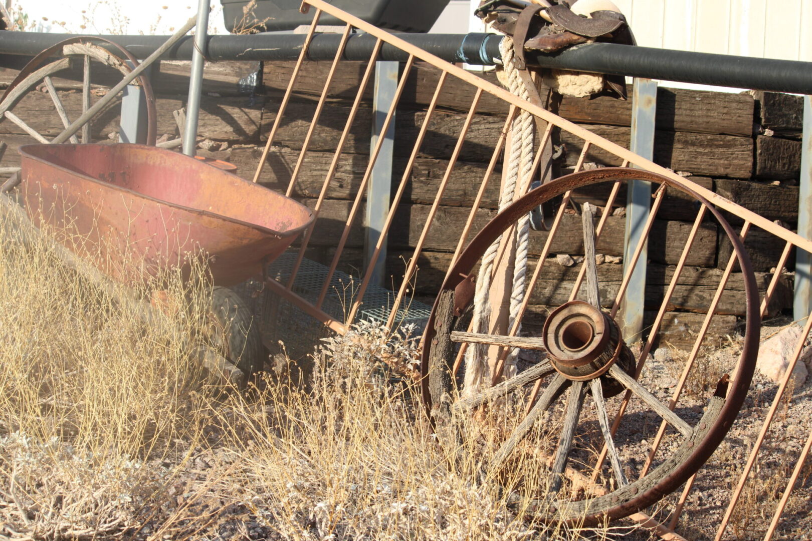 A person touching the wheel of an old wagon.