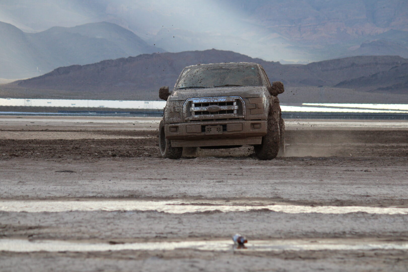 A truck driving down the road in mud.