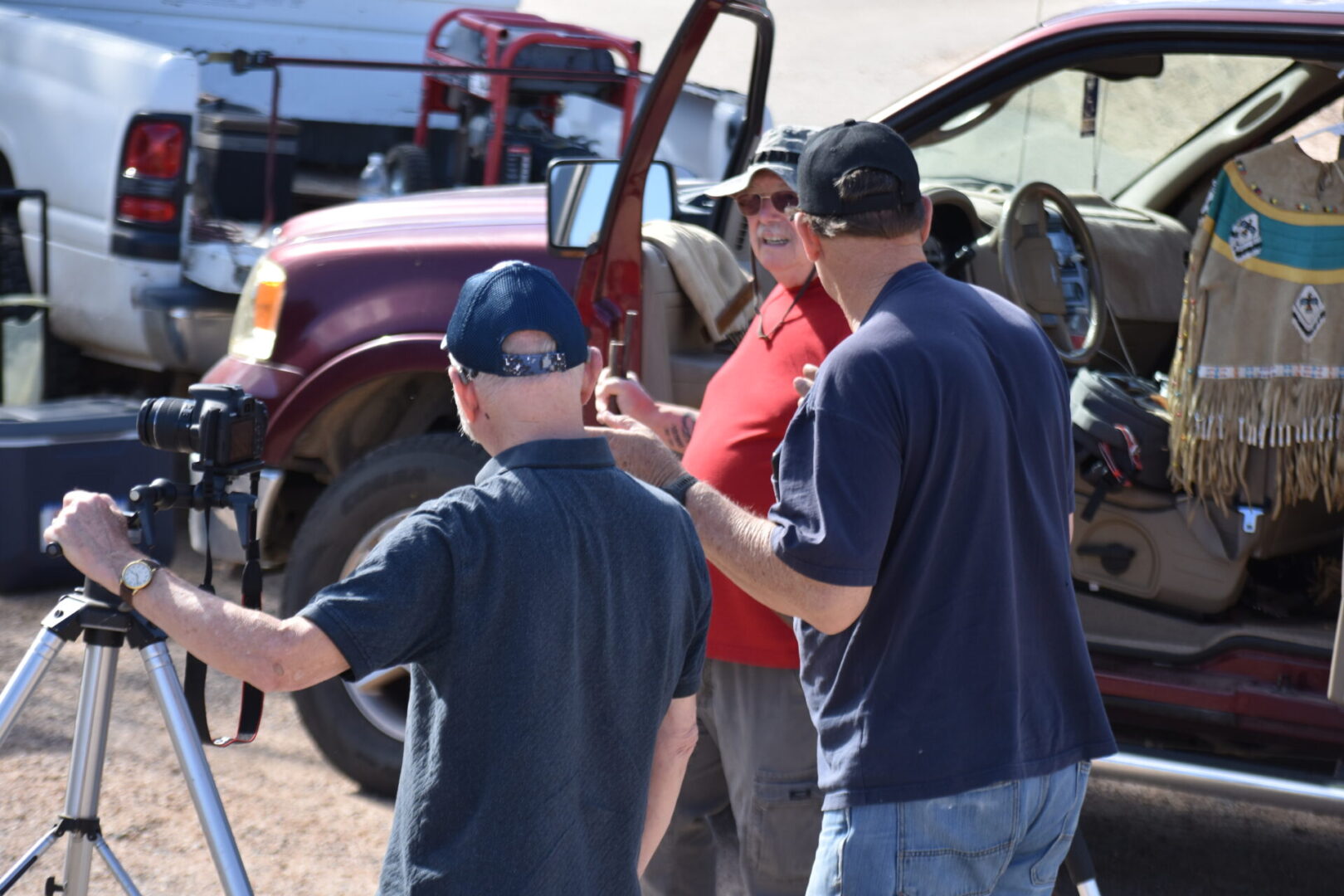 A group of people standing around in front of some trucks.