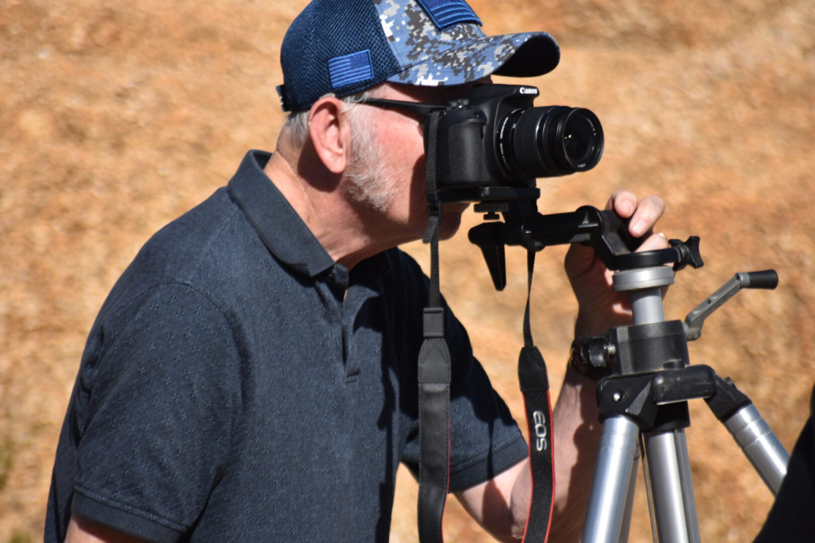 A man with a camera and tripod taking pictures.