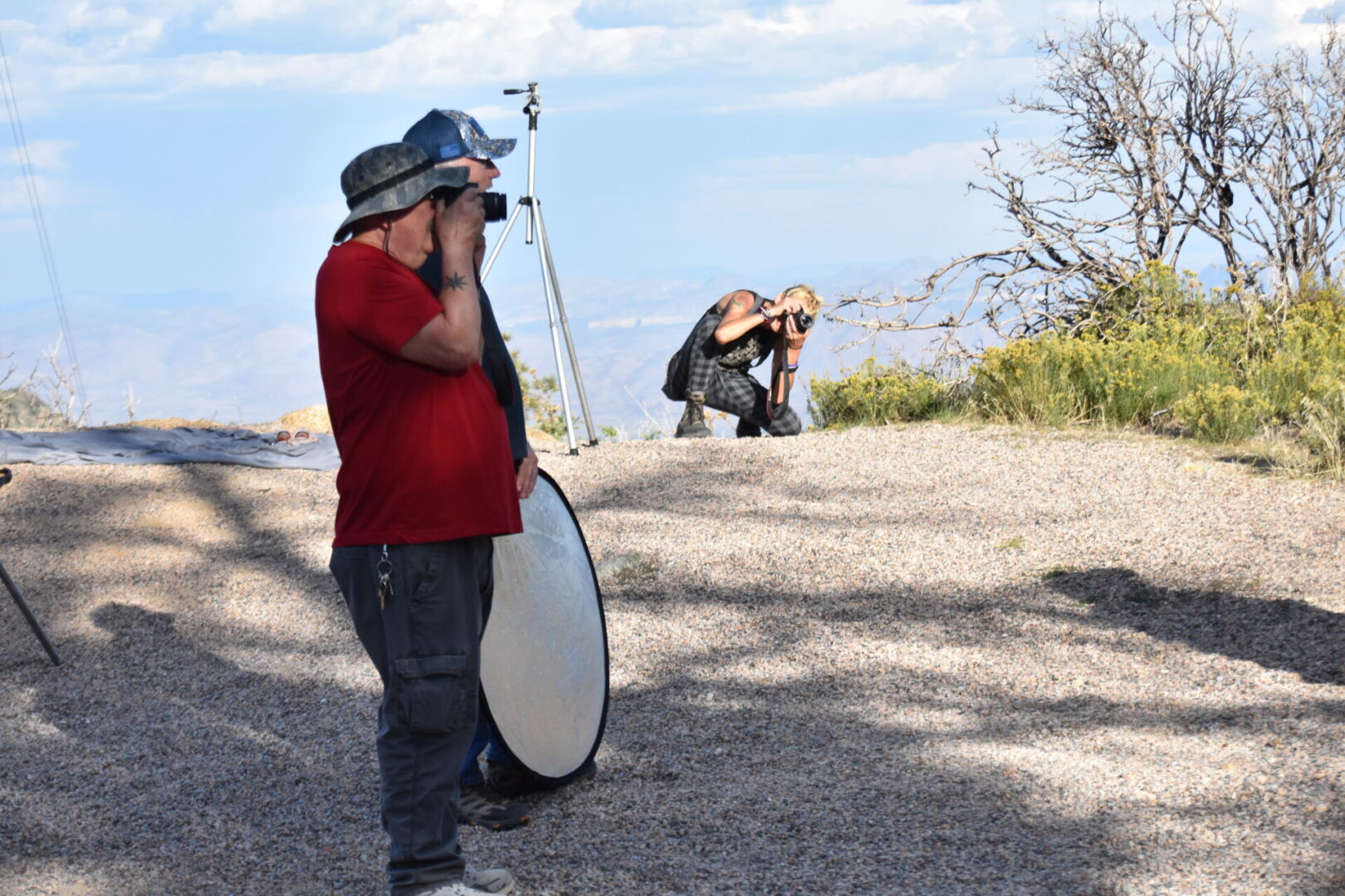 A man standing on the side of a road taking pictures.